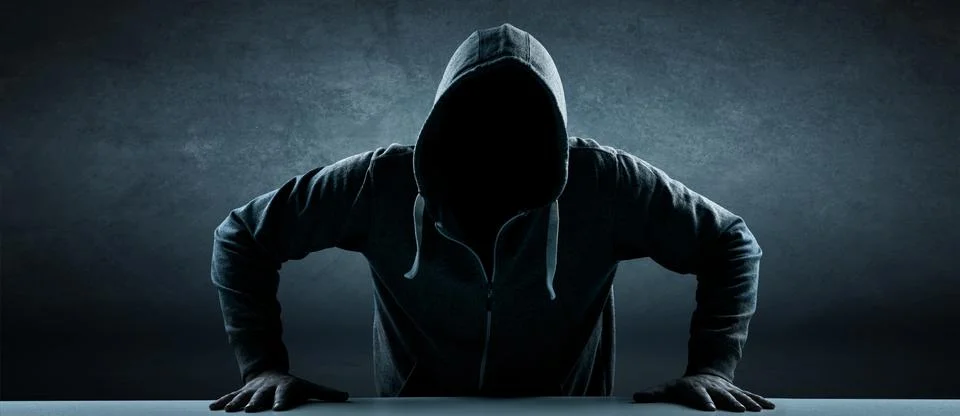 Anonymous internet hacker in front of computer. Web crime concept Stock Photos