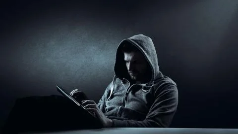 Anonymous internet hacker in front of computer. Web crime concept Stock Photos