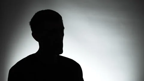 Anonymous interview with a man in a dark studio. Male silhouette. Vídeo Stock 309097810