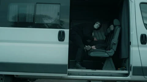 Anonymous Kidnapper in Mask Placing Unconscious Woman in Car Video stock 293630513