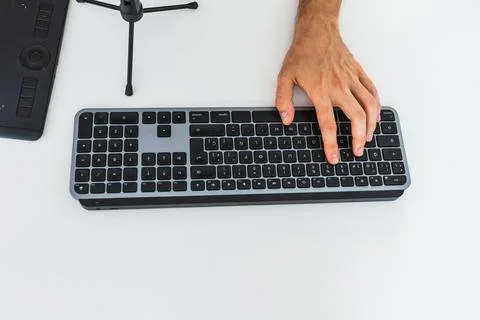 Anonymous male working on computer at table with graphic tablet Stock Photos