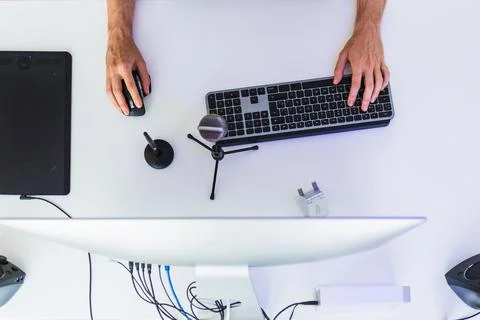 Anonymous male working on computer at table with graphic tablet Stock Photos