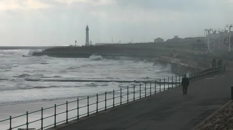 Anonymous man in dark clothing walks along the sea front promenade in winter Stock Footage 1097609