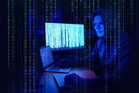 Anonymous man in mask with computers and binary code in darkness Foto stock