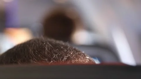 An anonymous man sitting on an airplane, from behind Stock Footage 63270175