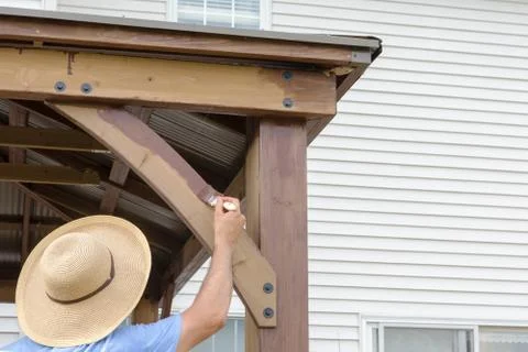 Anonymous man in a straw hat staining a gazebo Foto stock
