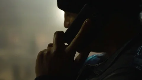 Anonymous man talking on phone in a dark room 库存影片 70224426