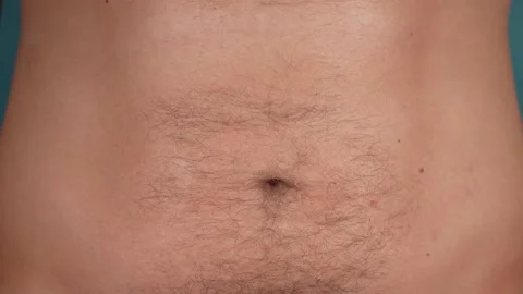 Anonymous man touching skin of his belly Stock Footage 168565599