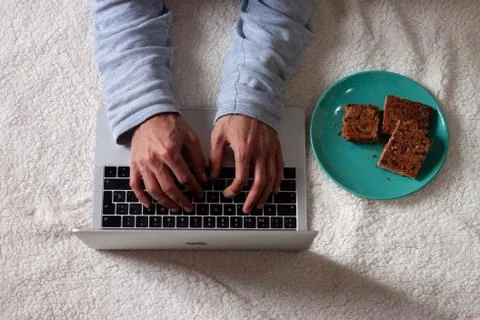 Anonymous man using computer while resting on the floor. White background Stock Photos