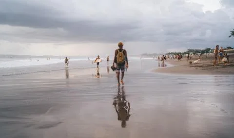 Anonymous man walking on sandy beach Stock Photos