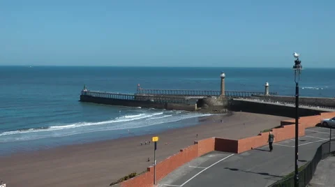 Anonymous man walks through empty seaside car park on Whitby Westcliffe Stock Footage 2921789