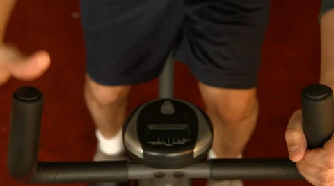 An anonymous man working out on a simple exercise bike, from above, captured in Stock Footage 68027546