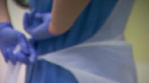 Anonymous Nurse Putting on a Disposable Apron Vídeos de archivo 146291375