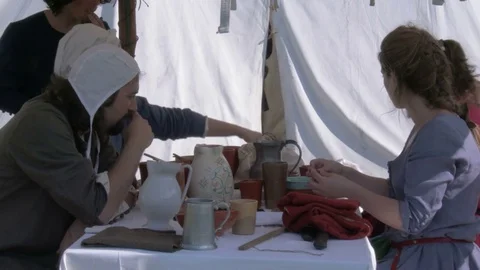 Anonymous people perform an example of daily meal in a medieval camp. Stock Footage 76202262