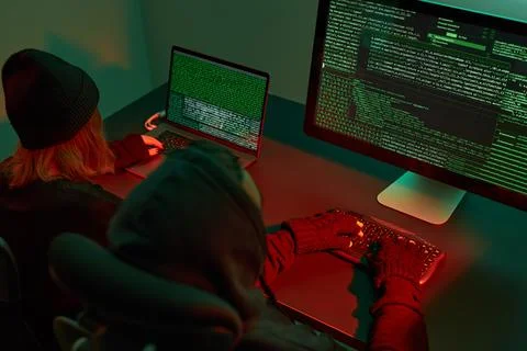 Anonymous people using computer and programming to break code. Cyber securi.. Stockfoto's