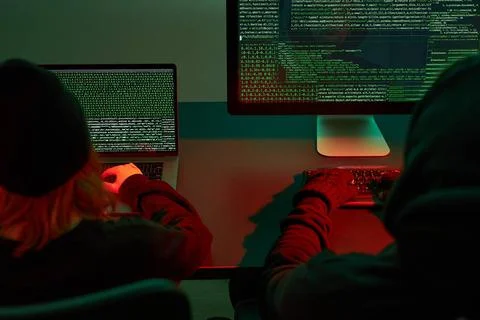 Anonymous people using computer and programming to break code. Cyber secur... Photos