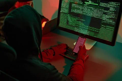 Anonymous people using computer and programming to break code. Cyber secur... 库存照片