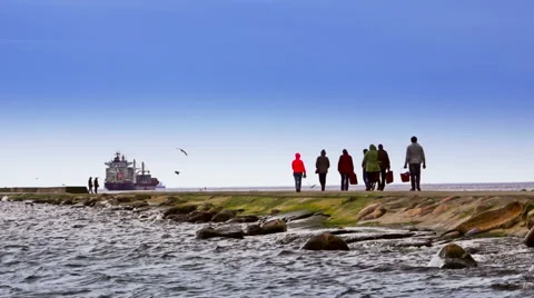 Anonymous people walking on a mole. Background containerships. Stock Footage 53187835