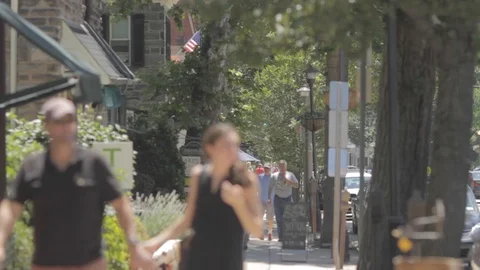 Anonymous people walking on a street in a wealthy small town Stock Footage