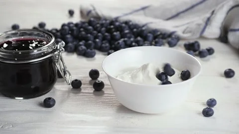 Anonymous person adding berries into yogurt Stock Footage 136671706