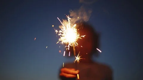 Anonymous person with burning firework Stock Footage 77563628