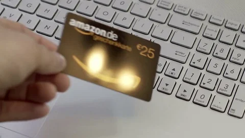 Anonymous Person Puts Amazon Germany Gift Card Onto Laptop Stock Footage 74992556