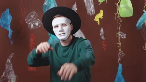 Anonymous person in white mask gesturing and posing on background with plastic Video stock 124932085