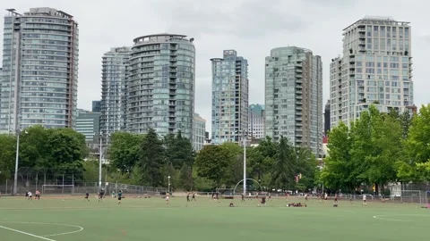 Anonymous soccer players playing in front of downtown building skyline Stock Footage 281703687