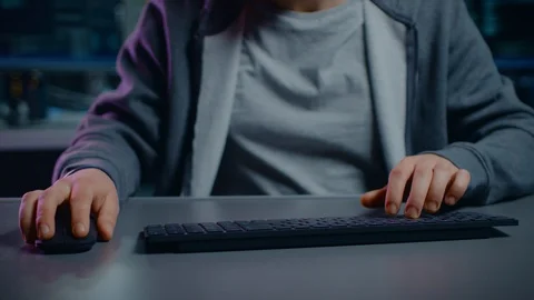 Anonymous Software Developer / Hacker Sitting at His Desk and Typing on Computer Stock Footage 103576277