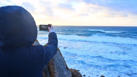 Anonymous take a selfie and make video of stormy sea winter at sunset coastline Stock Footage 106309588