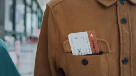 Anonymous Traveler with Ticket Visible in Jacket Pocket Crossing Airport Video stock 334562339