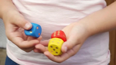Anonymous unrecognizable elementary school age child holding a set of three dice Stock Footage 167371101