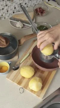 Anonymous user mash boiled potatoes in kitchen. Making mashed potatoes. High Stock Photos