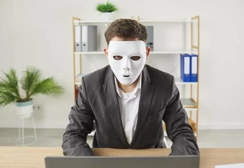 Anonymous web hacker with fake personality uses laptop computer for online fraud Stock Photos