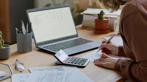 Anonymous Woman Adding Up Monthly Utility Payments on Calculator Stock Footage 302402510