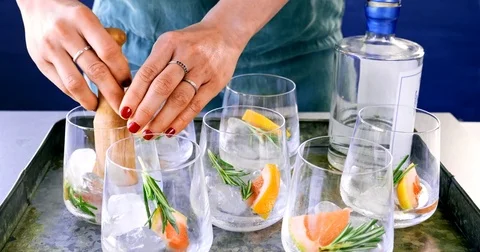 Anonymous woman bartender using muddler on cocktail drink glasses Video stock 81444330