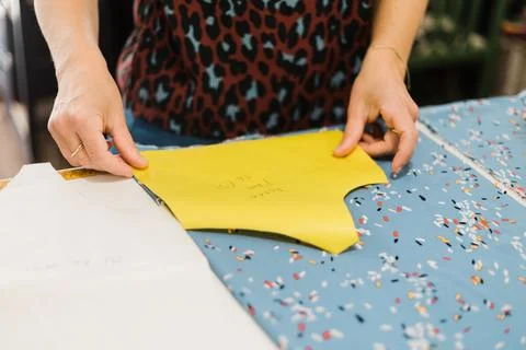Anonymous woman preparing pattern for sewing in atelier Stock Photos