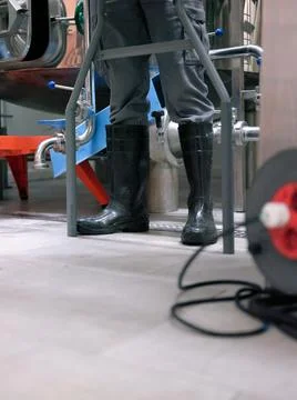 Anonymous worker with protective rubber boots in a brewery Stock Photos