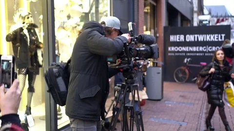 Anonymous young camera operator working with a cinema broadcast TV camera at Stock Footage 70429984