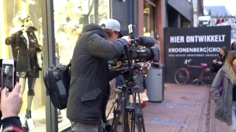 Anonymous young camera operator working with a cinema broadcast TV camera at Stock Footage 70429985