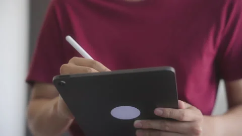 Anonymous Young man writing and drawing on tablet computer. Video stock 213583272