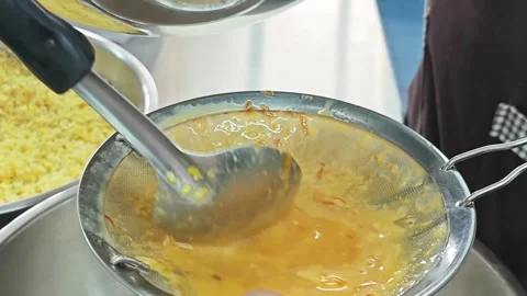 Another angle of filtering yellow batter through a strainer. Stock Footage 346537149