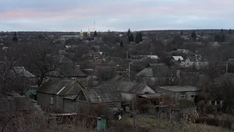 Another day of war ends with a somber sunset over a village on the Ukrainian Stock Footage 314087816