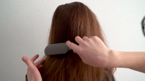 Another man combs the girl's long, thick red hair Stock Footage 148516581