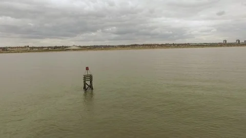 Another Place Crosby Murky beach on cloudy day over sea aerial shot Stock Footage 88976537
