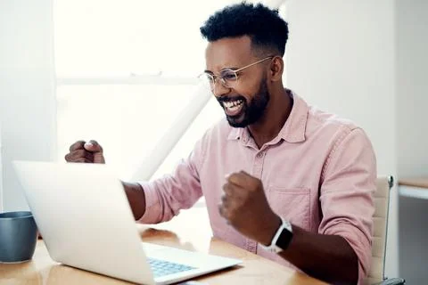 Another task done. a handsome young businessman sitting and alone celebrating Stock Photos