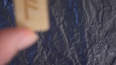 Ansuz rune. close-up, hand puts the rune on the surface for divination. 4k, slow Stock Footage 87879660
