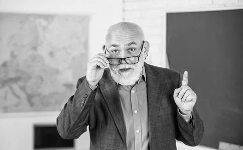 Answer and question. senior man teacher at blackboard. bearded tutor in glasses Stock Photos
