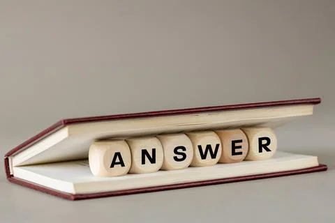 ANSWER concept. Word answer on wooden blocks placed in a book.  Stock Photos