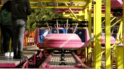 Antalya, Turkey - CIRCA 2022: Empty pink rollercoaster cart and start to ride Stock Footage 233478328